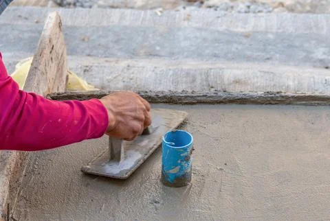 Plasterer man hand using trowel to plastering cement. Stock Photos