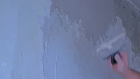 Plasterer man spackling wall with putty plaster aligning the wall, hand closeup. Video stock 123349604