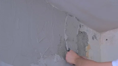 Plasterer man spackling wall with putty plaster aligning wall using trowel. Video stock 123350866