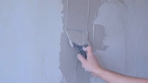 Plasterer man spackling wall with putty plaster aligning wall using trowel. Video stock 123351501