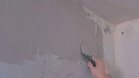 Plasterer man spackling wall with putty plaster aligning wall using trowel. Video stock 152961615