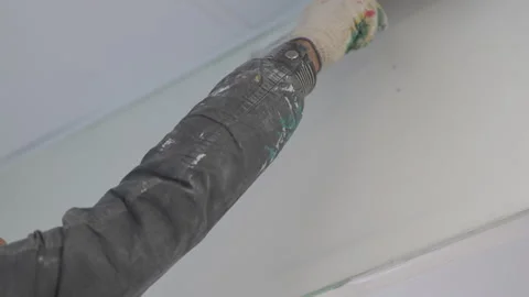 Plasterer moves trowel across wall spreading material evenly Stockbeeldmateriaal 316092544