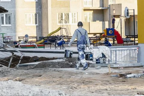 A plasterer or painter worker in dirty work clothes at a construction site. Stock-Fotos