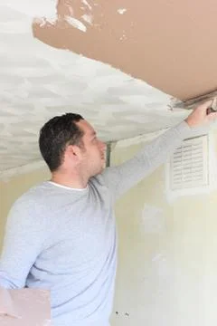 A plasterer plastering a ceiling Stock Photos