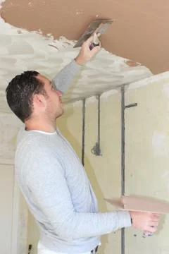 A plasterer plastering a ceiling Stock Photos