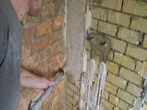 Plasterer plastering a wall with pipelines in a renovation bathroom Stock Footage 75668687
