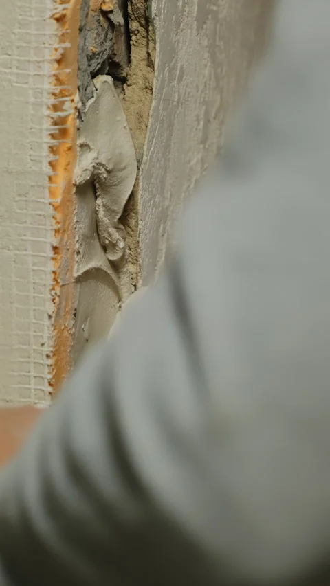 Plasterer presses fresh plaster against hole in wall Stock Footage 317081845