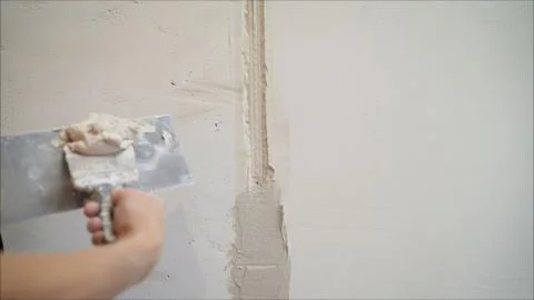 Plasterer putting plaster on wall. Worker covers the wall with mortar. Stock Photos