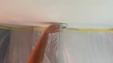 Plasterer sanding ceiling plaster with sandpaper Vídeos de archivo 341363402