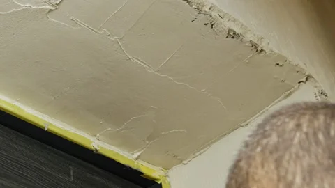 Plasterer seals slope coating wall with putty ensuring even finish Stock Footage 304422033