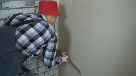 Plasterer smoothing dampened plaster with putty knife with free space Stock Footage 103939657