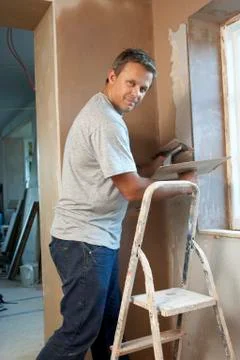Plasterer Working On Interior Wall Stock Photos