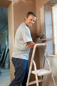Plasterer Working On Interior Wall Stock Photos