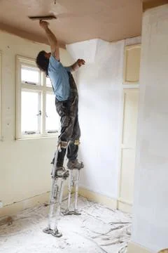 Plasterer working on stilts Foto stock