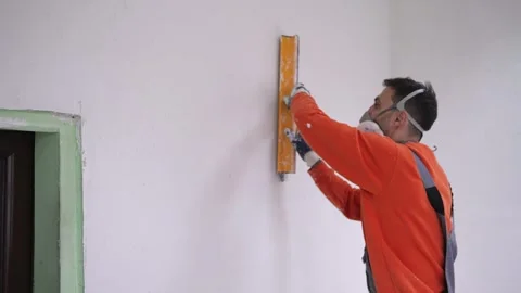 Plastering Process in Progress as Builder Smooths Wall Surface with Knife and Stock Footage 320163655