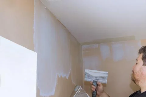 Plastering wall coating putty plaster on the wall Stock Photos
