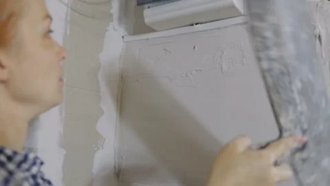 Plastering the wall. Hand holding a spatula with construction mix .Internal Vídeo Stock 165838266