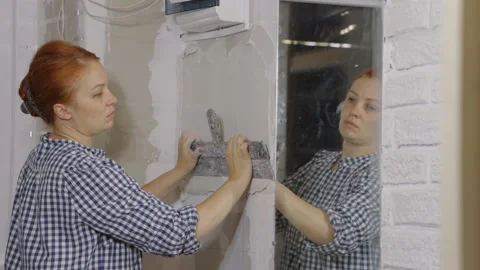 Plastering the wall. Hand holding a spatula with construction mix .Internal Stock Footage 165893850