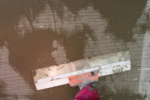 Plastering the wall with a spatula, working process Stock Photos
