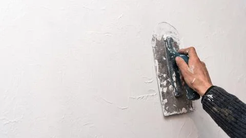Plastering wall, work with spatula, creating relief pattern on the wall, work Fotos Stock
