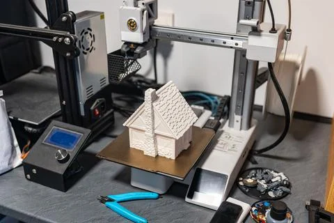 Plastic 3d printer working on printing a small house to scale for board games. Stock Photos