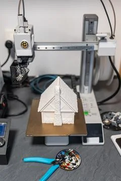 Plastic 3d printer working on printing a small house to scale for board games. Stock Photos