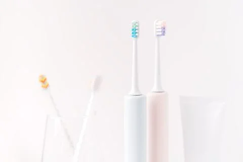 Plastic and electric toothbrushes with toothpaste against white background 스톡 사진