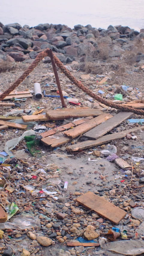Plastic and other garbage pollution on the embankment after a sea storm. vertica Stock Footage 169107525