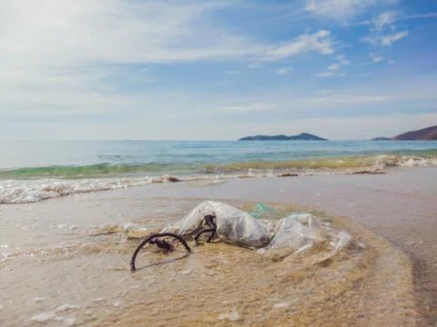 Plastic and ropes garbage on the beach with blue sky and clear water Stock Photos