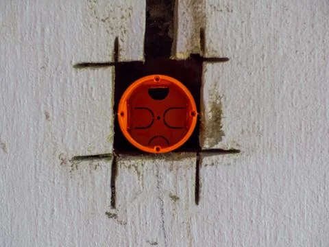 Plastic backbox for socket or switch inserted into the drilled hole on the wa Stock Photos