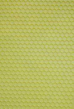 Plastic background in the form of salad-colored honeycombs. Textured corrugated Фото
