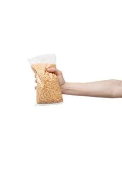 Plastic bag of beans held in hand isolated on white. man holding pack of peas Stock Photos
