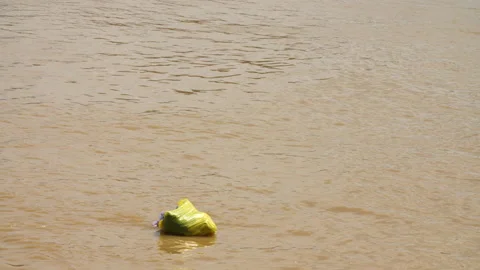 Plastic Bag Full of Waste Floating Down River, Borneo, 4K Stock Footage 148192182