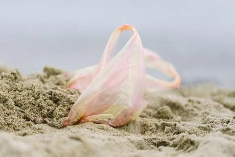 Plastic bag left on sandy beach Stock Photos