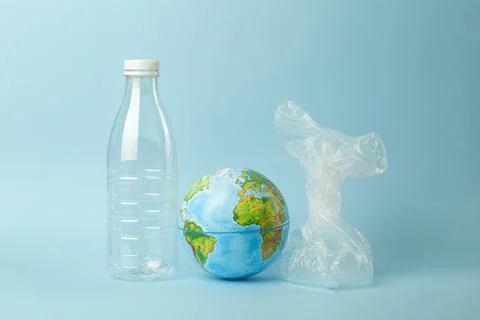 Plastic bag pollution concept. Earth globe in a plastic bag on a colored Stock Photos
