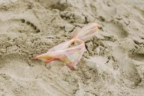 Plastic bag in sand on a beach Stock Photos
