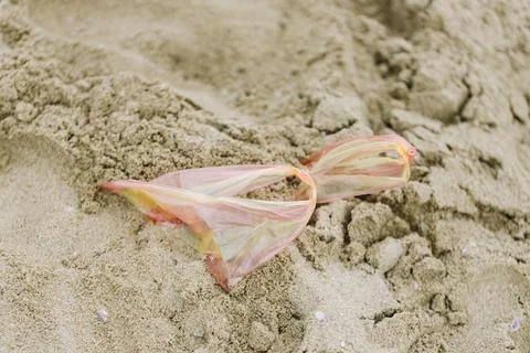 Plastic bag in sand on a beach Stock Photos