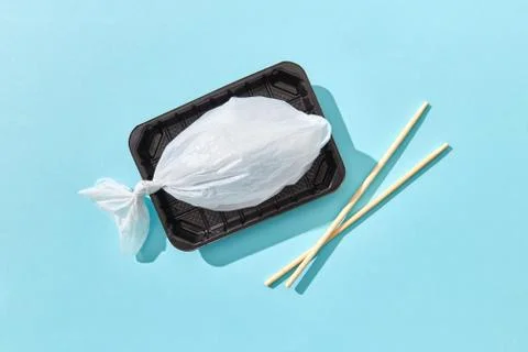 Plastic bag in a shape of fish on a plastic plate with chopsticks. Fotos de archivo