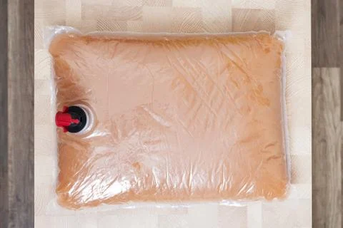 Plastic bag with tap full of apple juice Stock Photos