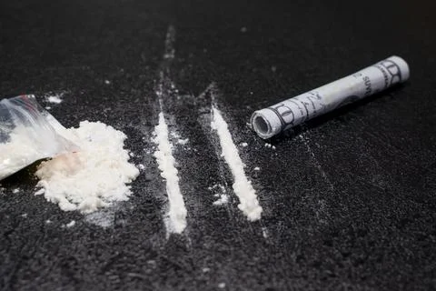 Plastic bag, two lines and a bunch of cocaine with a breathing tube with hundred Stock Photos