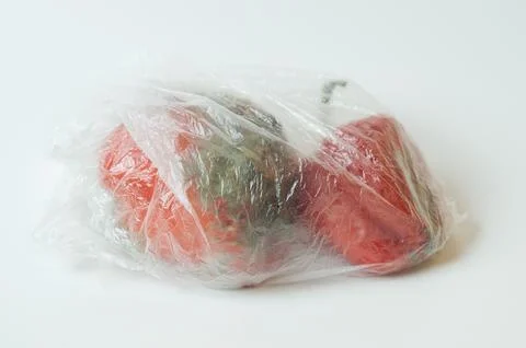 Plastic bag with two spoiled rotten tomatoes on white background. Stock Photos