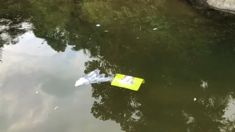 Plastic bags floating on the surface of river water Stock Footage 231123050