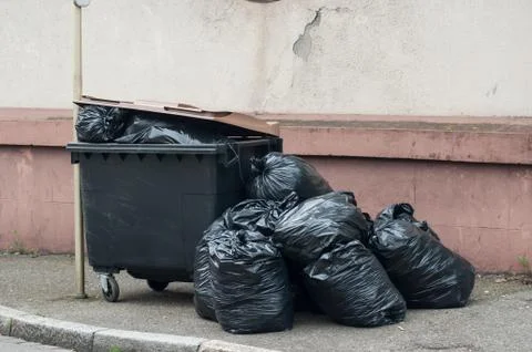 Plastic bags garbage stack near container in the street Foto stock