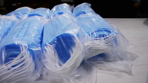 Plastic bags with protective masks on table and inside box Stock Footage 133409601