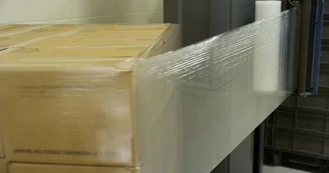 Plastic being wrapped around cardboard boxes Stock Footage 104000054