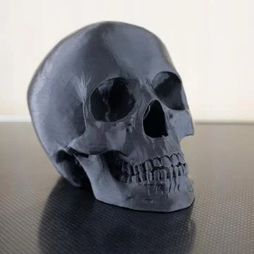 Plastic black skull on a white background Stock Photos