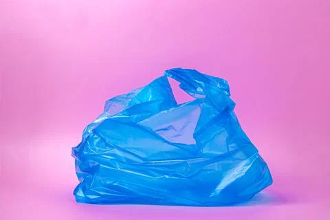 Plastic blue bag on a pink background.  Stock Photos