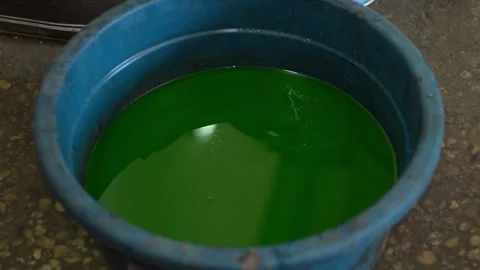 A plastic blue basin filled with bright green car coolant or antifreeze liqui Stock Footage 345109125