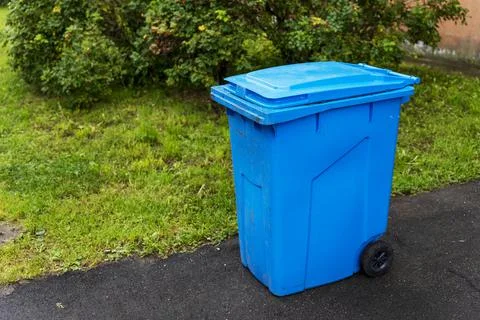 Plastic blue garbage container in the courtyard of a residential building Foto stock