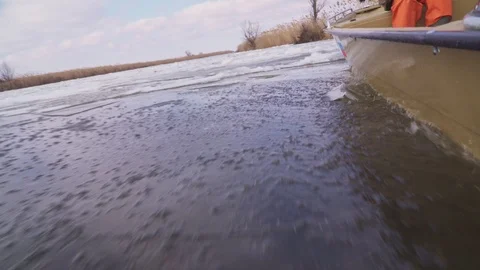 Plastic boat breaks through sharp ice floes on the river Stock Footage 102345795